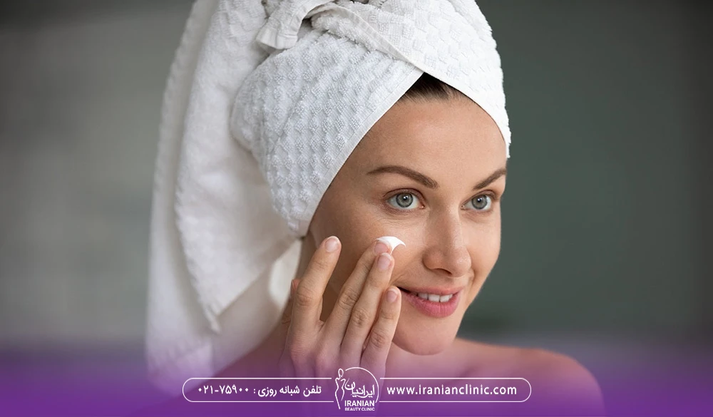دختری که روی گونه خود کرم مرطوب کننده می مالد