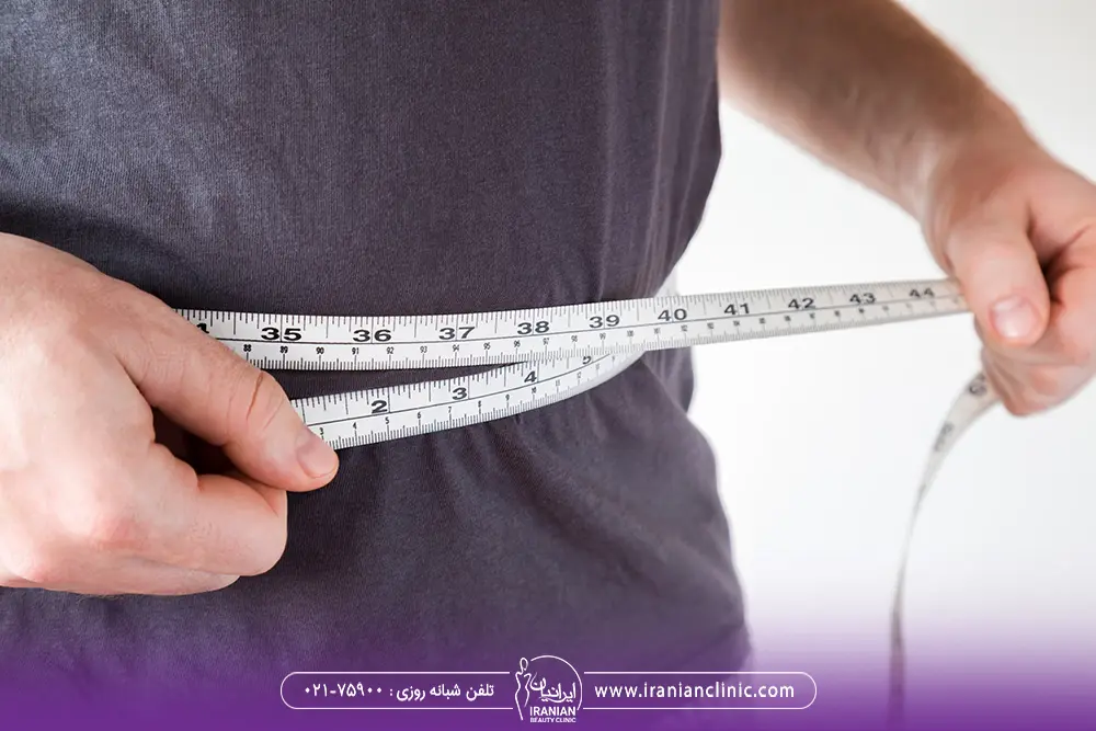 مردی که یک متر دور کمر خود گرفته است و دور شکم خود را اندازه می گیرد