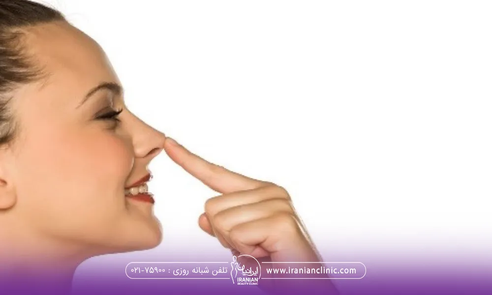 نیمرخ دختری که با انگشت دستش نوک بینی اش را به بالا فشار می دهد و میخندد