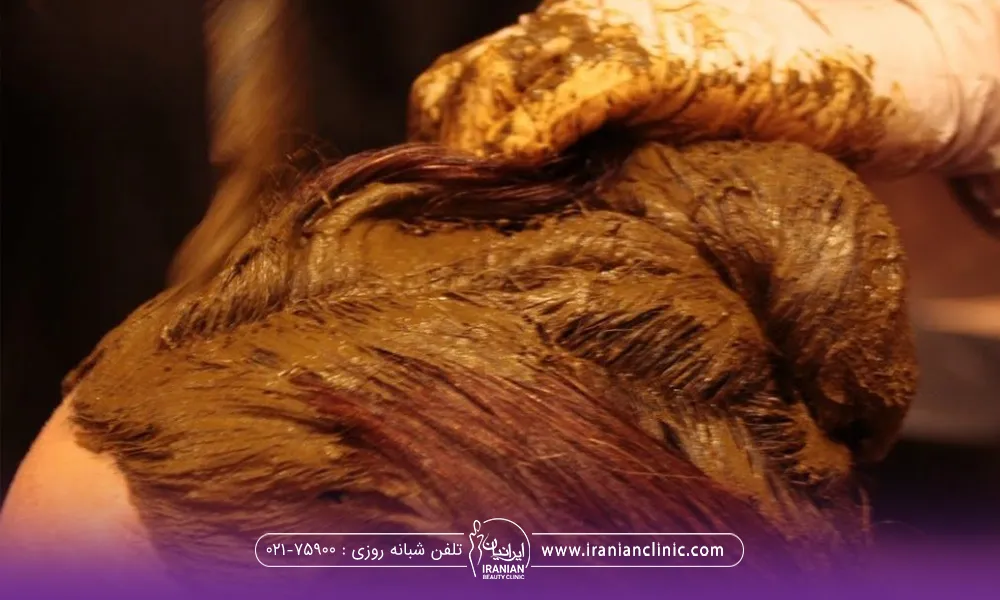 سر یک فرد که فرد دیگری به موهای او حنا مالیده است