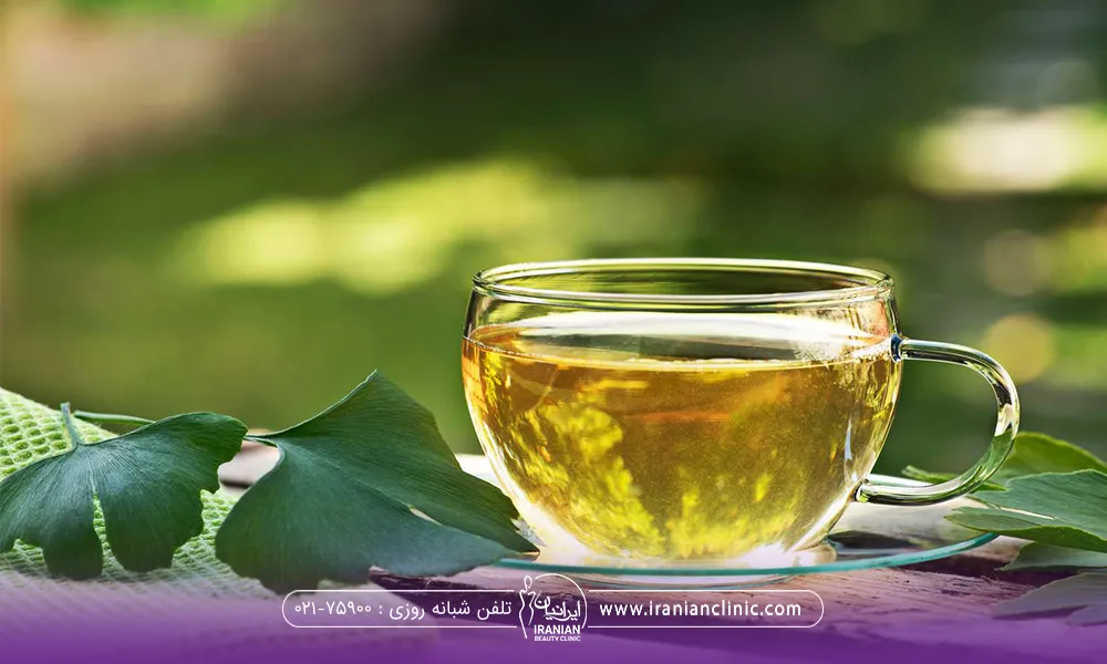 یک فنجان دمنوش کُهَن دار یا جینکو بیلوبا و یک برگ جینکو بیلوبا کنارش قرار گرفته است